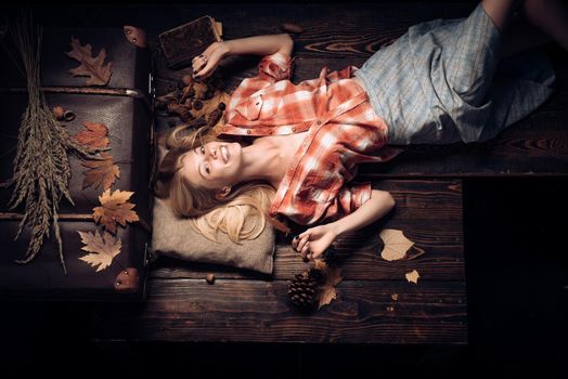 Autumn mood and weather warm and sunny and rain is possible. Sweet young woman playing with leaves and looks very sensually. Autumn concept. Background with autumn leaves. Beautiful sensual blonde