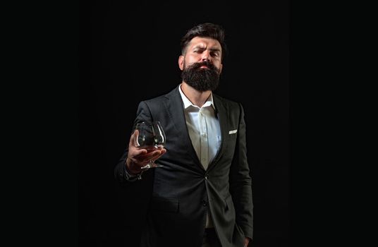 Businessman gets rid of stress with cognac. Bearded businessman in elegant suit with glass of cognac. Man Bartender holding glass of cognac