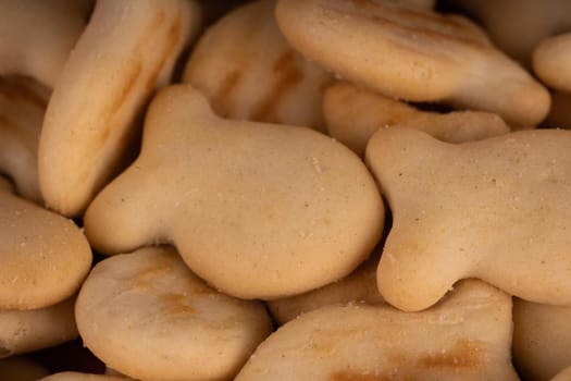 Texture of salted crackers. Close up of cookies in form of fish. Concept of background for your text