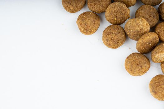 Dry food in right corner on white background. Close up of useful pet food. Concept of space for your text