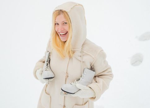 Happy winter fun woman. Happy young woman walking in winter time. Beautiful smiling young woman in warm clothing with ice skates