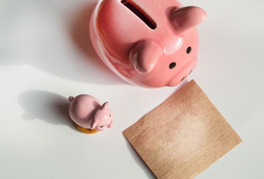 Two cute pink piggy banks on a white background and a wrapping paper layout with a copy of the space and place for the text.