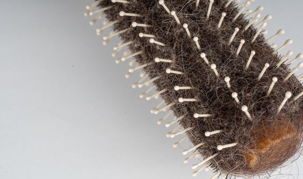 Close up of old dirty hairbrush. Comb with different hair on white background