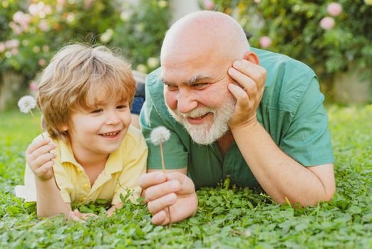 Portrait of happy senior man father smiling and happy cute son. Father and grandfather. Happy family Grandson hugs his grandpa on holiday. Happy grandfather and grandson relaxing together