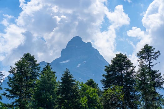 Peaks of magnificent rocks located against bright cloudy sky on sunny day in nature.