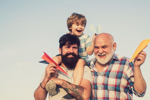 Weekend family play. Men in different ages. Leisure activity. Kid pilot with toy jetpack against sky background. Father son and grandfather playing - family time together