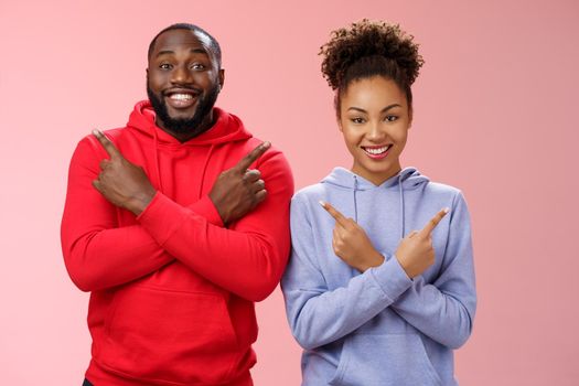 Charming happy couple african american boyfriend girlfriend move in together pointing different sides cross arms chest left right smiling broadly upbeat have variety good choices opportunities.