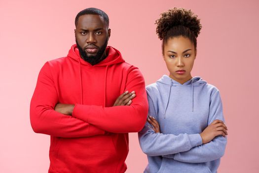 Two attractive african friends coworkers serious-looking standing confident strong pose arms crossed chest look determined focused camera wanna beat rival team computer game, self-assured.