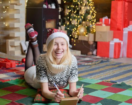 Christmas is coming. Wish you merry Christmas. Wish list. Woman cozy knitted sweater enjoy christmas atmosphere at home. Happy laughing woman