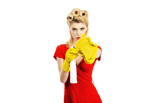 A beautiful young woman holds a rag and spray for washing windows. Isolated on a white background. Cleaning lady with a gloves in the hands