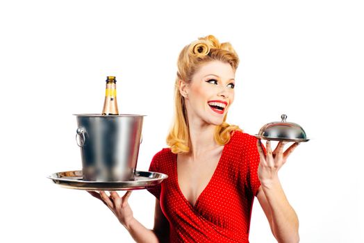 Beautiful blonde woman in red dress with retro hairstyle. Happy girl with champagne bottle and tray. Pin up style. Happy excited woman in retro dress with beautiful hairdo