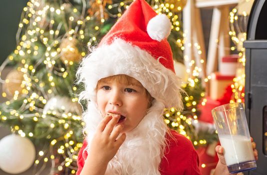 Portrait of Santa Claus Drinking milk from glass and holding cookies. Milk and gingerbread cookie for Santa against Christmas light bokeh background. Santa Claus