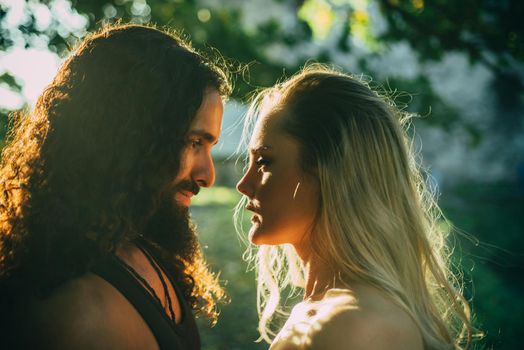 Beautiful dreamy woman looking in her boyfriends eyes. Couple in sunshine. Sensual couple in love walking in the park. Loving couple going to kiss. Trust and tender feelings concept