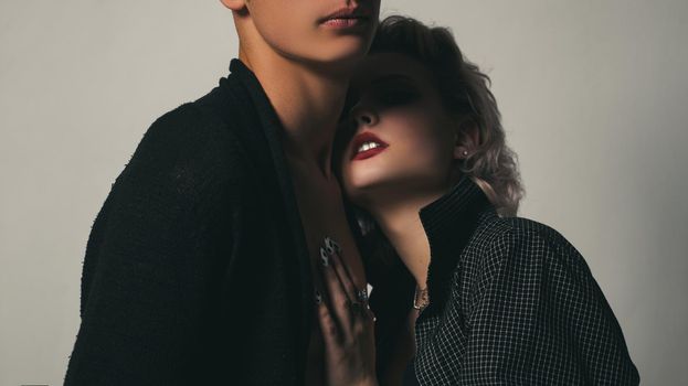 Affectionate couple having a fun while a photo session. Young heterosexual couple embracing. Close up photo. Portrait of happy loving couple. Handsome guy is hugging pretty girl with short hair