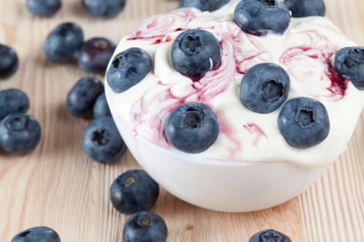 berries blue bog, cream or sour cream and blueberry jam, used during the preparation of dessert, closeup