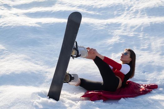 Girl have fun and enjoy the fresh snow on a beautiful winter day in the mountains. Extreme winter sports. Young athlete female. Woman snowboarder on the slopes winter day