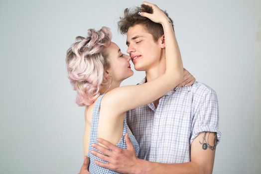 Young happy couple posing in studio.Gorgeous woman with long blond hair posing with handsome brunette man with sportive muscular man. Valentines day. Beautiful playful woman want kiss man