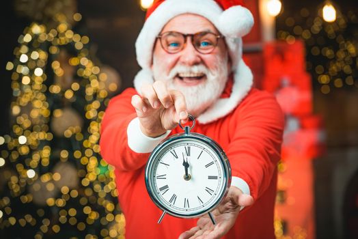 Portrait of Santa Claus holding alarm clock. Happy new year. Photo of Santa holding clock showing five minutes to midnight