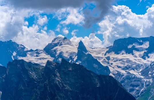 The rocky mountains were shrouded in clouds on a Sunny day.