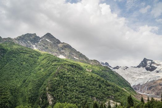 Peaks of magnificent rocks located against bright cloudy sky on sunny day in nature.