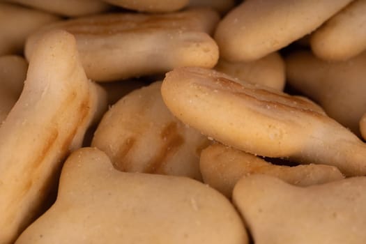 Texture of salted crackers. Close up of cookies in form of fish. Concept of background for your text