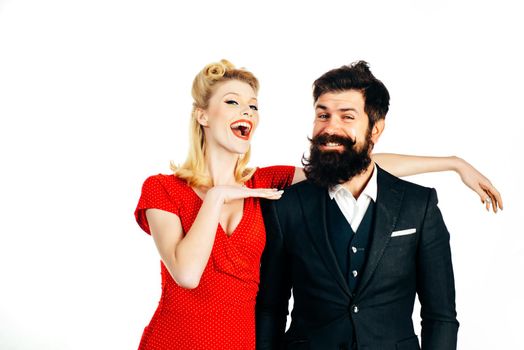 Beautiful woman with luxury hairstyle wearing red dress and handsome bearded man isolated at white background. Crazy happy couple in love play tricks and have fun together