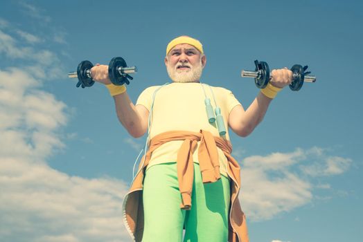 Healthcare cheerful lifestyle. Senior man lifting dumbbell. Freedom retirement concept. Age is no excuse to slack on your health