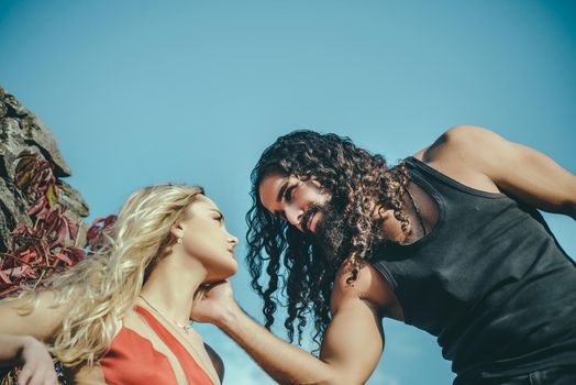 Happy young couple in love spending time together during their romantic date. Handsome charming man touching his girlfiends face, looking in her eyes and feeling romantic