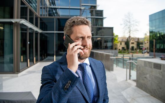 cheerful successful bearded businessman in formal suit speaking on smartphone, negotiation.