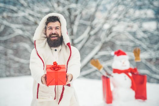 Happy new year. Happy father playing with a snowman on a snowy winter walk. Santa Claus wishes Merry Christmas