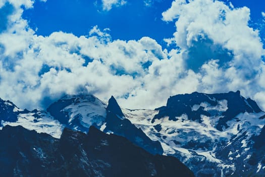 Mighty mountains with snow in cloudy weather.