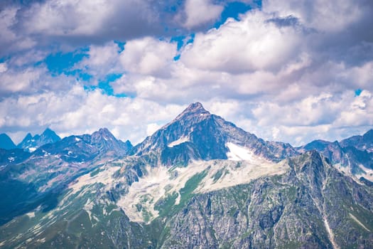 Peaks of magnificent rocks located against bright cloudy sky on sunny day in nature.