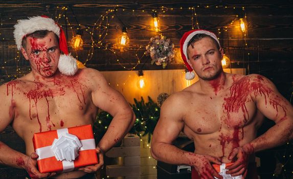 Men handsome in blood with gift boxs surprise. Merry Christmas and Happy Holiday. Handsome men or sexy christmas guys with muscular body, chest and torso in red santa claus hats. Young athletic Santa Claus. Happy new year