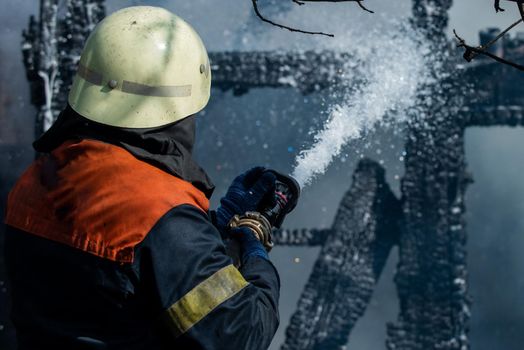 Brave firefighter saving burning building. Firefighter work concept. Firefighter are using water in fire fighting operation. Real brave hero combat the fire with foam extinguisher