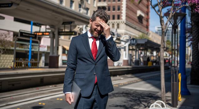 stressed freelance man hold pc outdoor, employer.