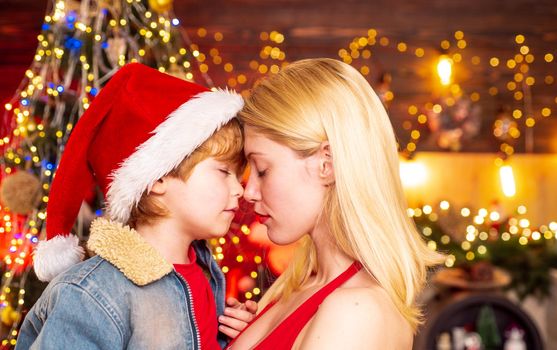 Sensual photo of baby boy and girl close to each other at New Year decorated tree. Helper of Santa with a Christmas magic gifts. Portrait of happy mother and adorable baby celebrate Christmas