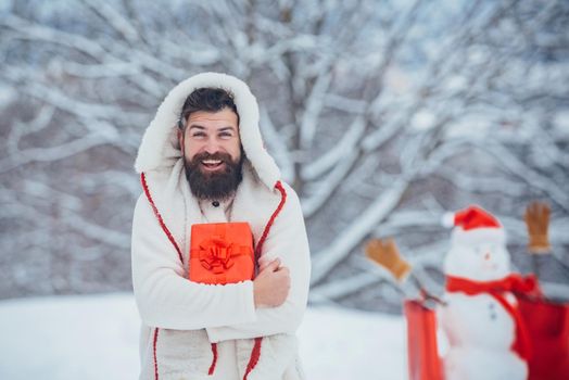 Man in Christmas dress with gift near the Christmas background. Man in Christmas dress with gift near the Christmas background