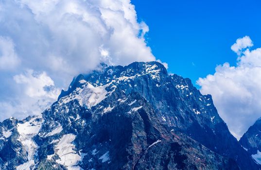 The rocky mountains were shrouded in clouds on a Sunny day.