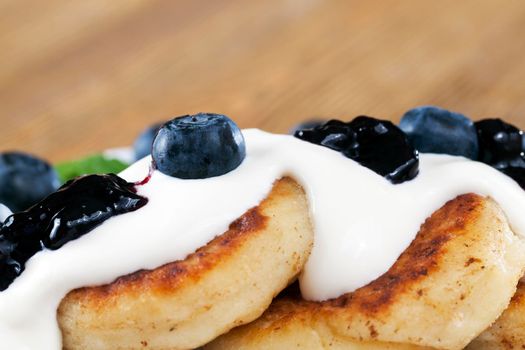 fried curd cheese cakes with blueberry jam and blueberry berries Serving dinner, closeup