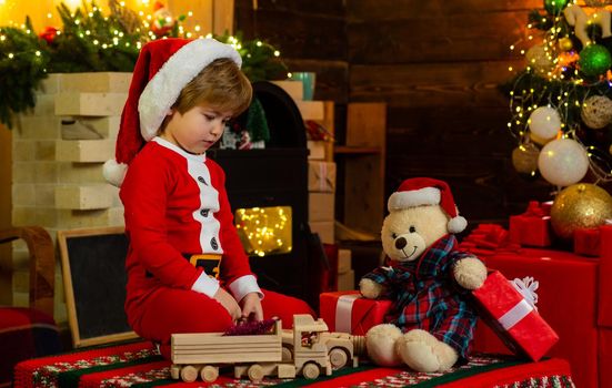 Favorite toy. Family holiday. Childhood memories. Santa boy little child celebrate christmas. Boy child play near christmas tree. New year countdown. Merry and bright christmas. Baby enjoy christmas.