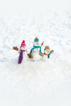 Funny group of snowmen family - New Year greeting card. New Year banner. Snowman group on the white snow background