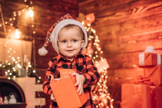 Happy child with Christmas gift box. Surprise . Present box. A little boy in warm clothes.Merry Christmas and happy New year