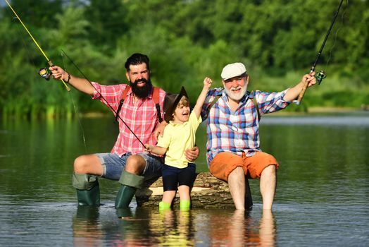 Hobby and sport activity. Happy people family have fishing and fun together. Dad and son fishing at lake. Grandpa and grandson are fly fishing on river