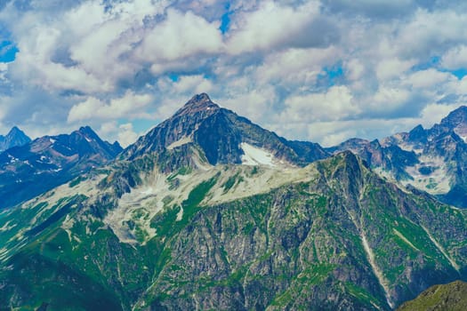 Peaks of magnificent rocks located against bright cloudy sky on sunny day in nature