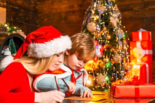 Mum and kid writing a letter to Santa with wish list of Christmas presents.Christmas interior. Merry christmas and happy new year. Bright New Years interior concept