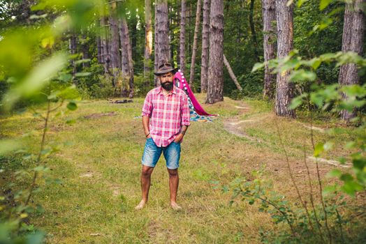 Natural background. Bearded man relax in forest. Mature hipster with beard. Guy in forest. Summer camping. Serious bearded man