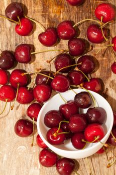 red ripens cherry, ripped from trees during harvest. Photo close-up. Berries lie in a porcelain dish