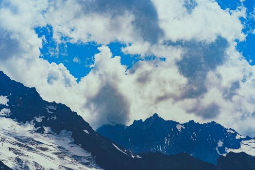 Mighty mountains with snow in cloudy weather.