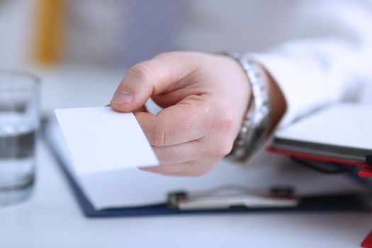 Male arm in suit give blank calling card to visitor closeup. White collar colleagues company name exchange job interview sale clerk id executive or ceo finance support formal identity concept