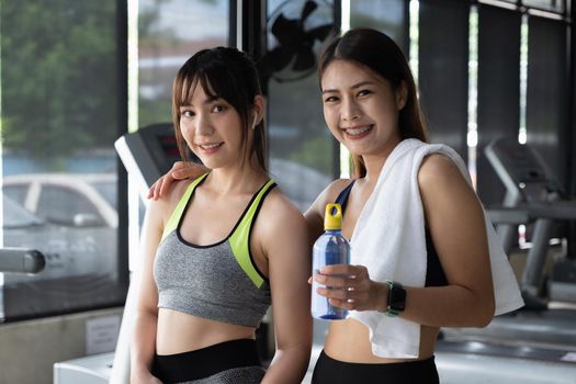 Portrait two spoty girl smiling fitness after working out training together in gym